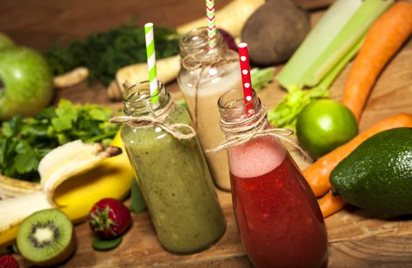 Assortiment van groenten en fruit smoothies in glazen flessen met rietjes — Stockfoto