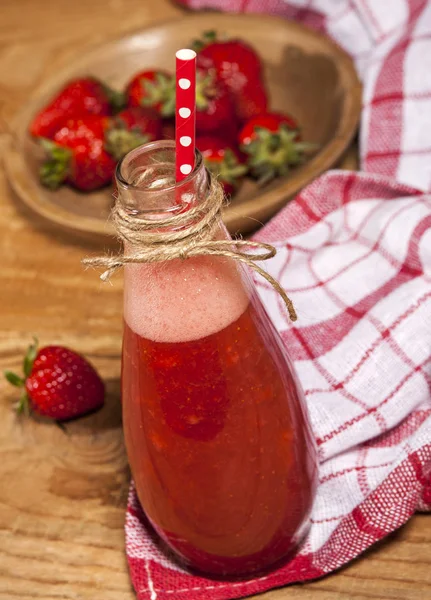 Strawberry smoothie or milkshake in bottle on wooden rustic background. — Stock Photo, Image