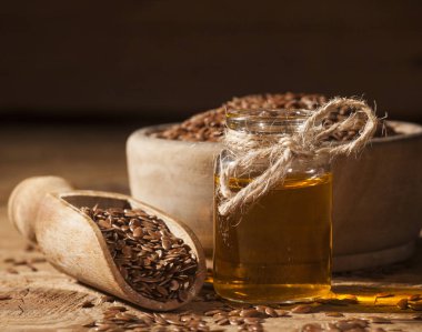 Keten tohumu yağı ve linseeds ahşap arka plan üzerinde kase