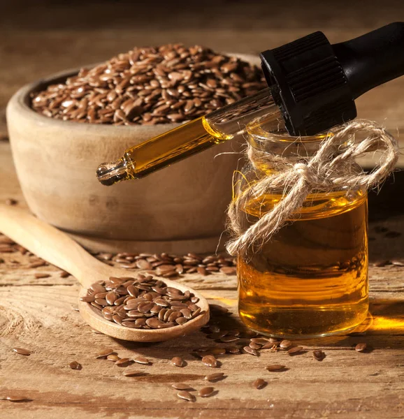 Keten tohumu yağı, kaşık ve linseeds ahşap arka plan üzerinde kase