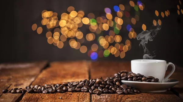 Coffee cup and coffee beans on a wooden table and bokeh background — Stock Photo, Image