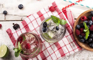 Ahududu, böğürtlen ve beyaz arka plan üzerinde yaban mersini ile yaz soğuk içecekler