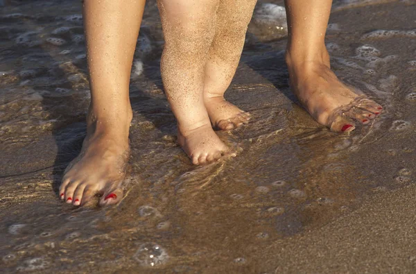 Barnet gör sina första steg på stranden — Stockfoto