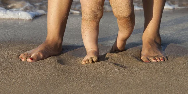 Dítě dělá jeho první kroky na pláži — Stock fotografie