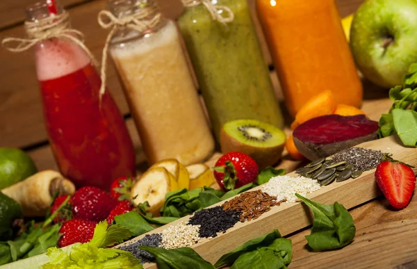 Ассортимент фруктово-овощных коктейлей в стеклянных бутылках с соломинками — стоковое фото