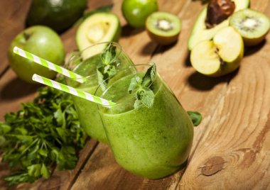 Gözlük payet ile taze karıştırılmış yeşil smoothie. Ahşap arka plan.