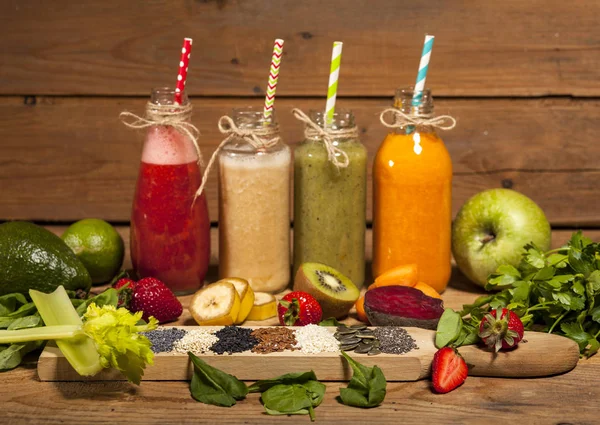 Assortiment van groenten en fruit smoothies in glazen flessen met rietjes — Stockfoto