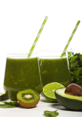 Gözlük payet ile taze karıştırılmış yeşil smoothie. Beyaz ahşap zemin.