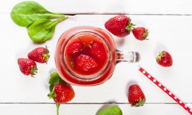 Çilek güler yüzlü ya da muzlu süt beyaz arka plan üzerinde bir kavanoza.