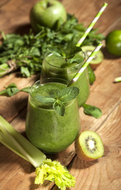 Gözlük payet ile taze karıştırılmış yeşil smoothie. Ahşap arka plan.