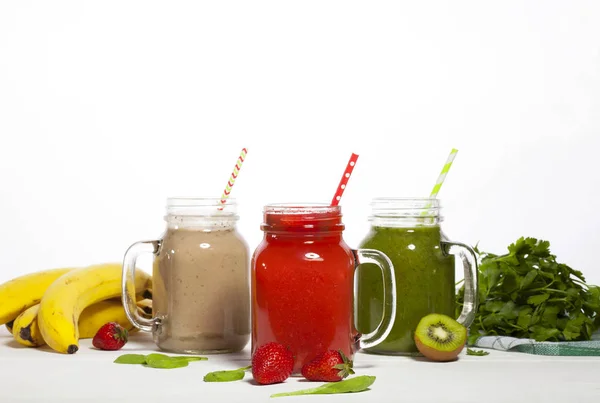 Sortiment av frukt och grönsaker smoothies i glas burkar med sugrör — Stockfoto