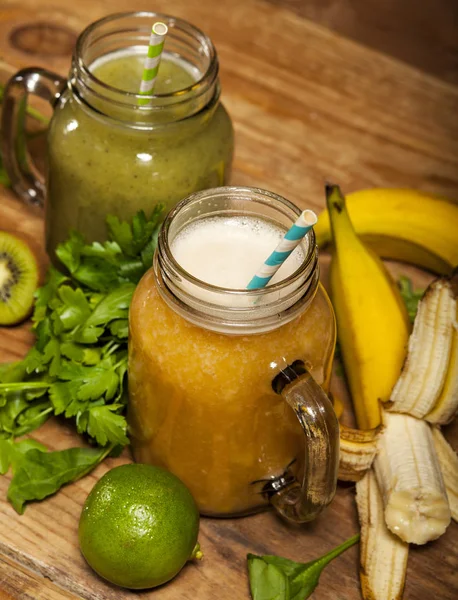 Sortiment av frukt och grönsaker smoothies i glas burkar med sugrör — Stockfoto