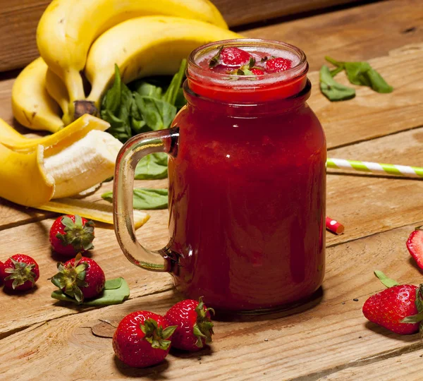 Strawberry and banana smoothie or milkshake in a jar on wooden background. — Stock Photo, Image