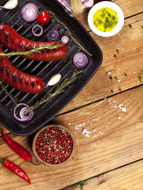 Ahşap arka plan üzerinde bir tavada ızgara sosis