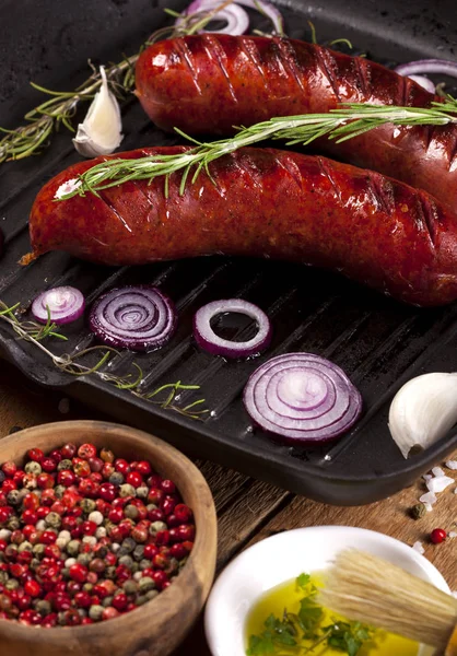 Close up of grilled sausages in a pan on wooden background — Stock Photo, Image