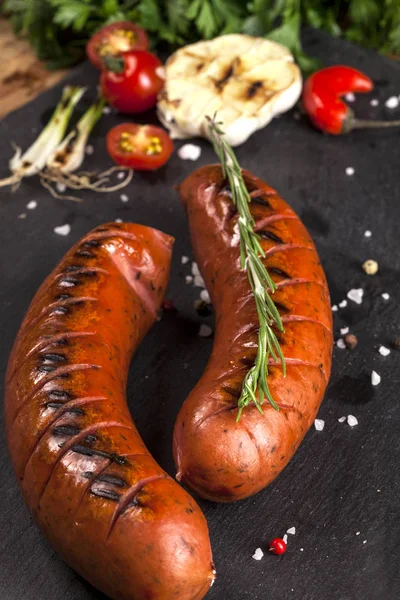 Embutidos a la parrilla sobre fondo negro — Foto de Stock