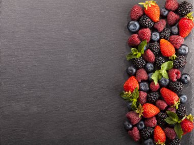 Siyah arka plan üzerinde olgunlaşmış ve tatlı çilek