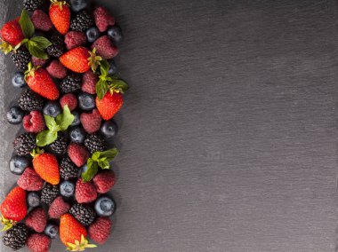 Siyah arka plan üzerinde olgunlaşmış ve tatlı çilek