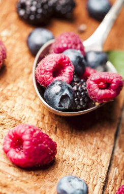 Ahşap arka plan üzerine bir kaşık olgun ve tatlı çilek