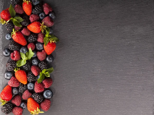 Siyah arka plan üzerinde olgunlaşmış ve tatlı çilek