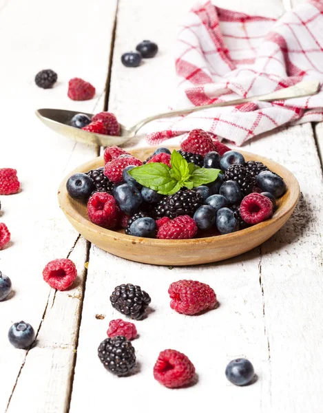 Ahşap beyaz zemin üzerine kabın içinde olgunlaşmış ve tatlı çilek