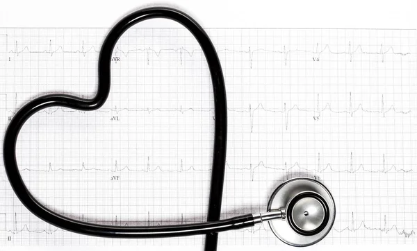 Fonendoskop ve tvaru srdce na elektrokardiogramu. — Stock fotografie