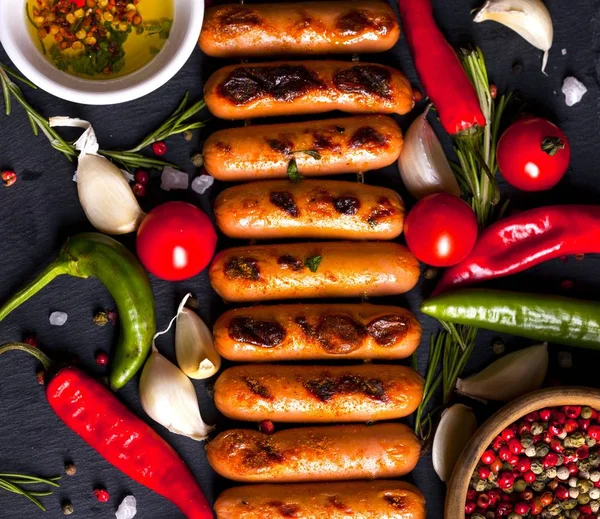 Otlar, baharatlar ve sebzeler siyah arka plan üzerine Kızarmış sosis