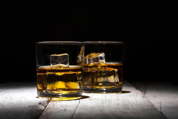 Beyaz ahşap plakalar üzerinde iki bardak viski buz küpleri ile hizmet. — Stok fotoğraf