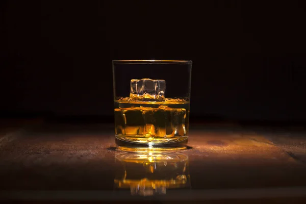 Glas Whisky mit Eiswürfeln, serviert auf Holzplanken. — Stockfoto