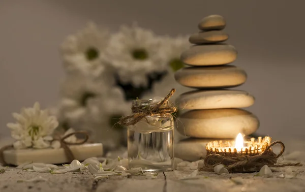 Kamille etherische olie, boeket van kamille bloemen, stapel van rotsen en kaars — Stockfoto