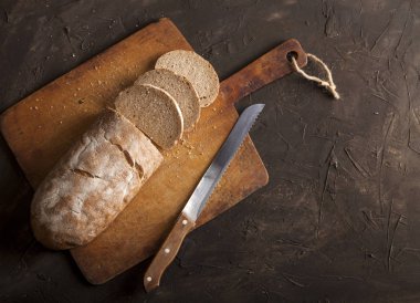 Geleneksel ekmek dilimlenmiş ve karanlık bir masada.