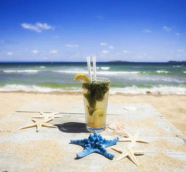 Cocktail Mojito en la playa de arena dorada cerca del agua. — Foto de Stock