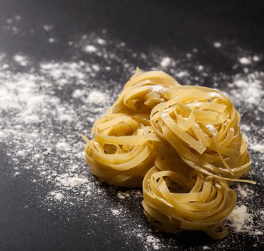 Siyah taş zemin üzerinde geleneksel İtalyan çiğ makarnası