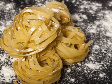 Siyah taş zemin üzerinde geleneksel İtalyan çiğ makarnası