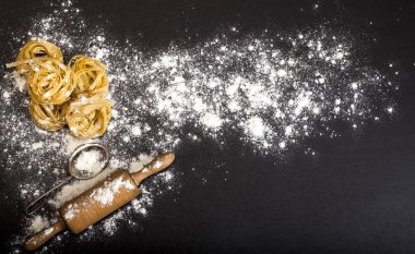 Siyah taş arka planda İtalyan geleneksel çiğ makarnası, üst manzara.