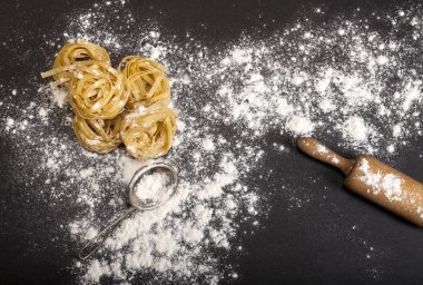 Siyah taş arka planda İtalyan geleneksel çiğ makarnası, üst manzara.