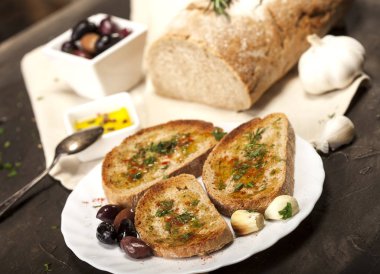 Zeytinyağı, zeytin, sarımsak ve otla dilimlenmiş geleneksel tost ekmeği.