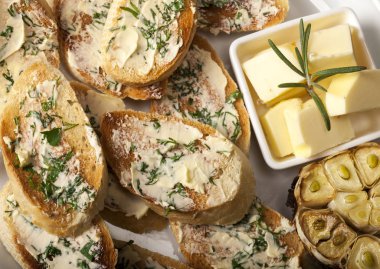 Beyaz tabakta tereyağlı, sarımsaklı ve otlu geleneksel tost ekmeği.