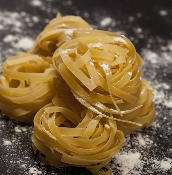 Siyah taş zemin üzerinde geleneksel İtalyan çiğ makarnası