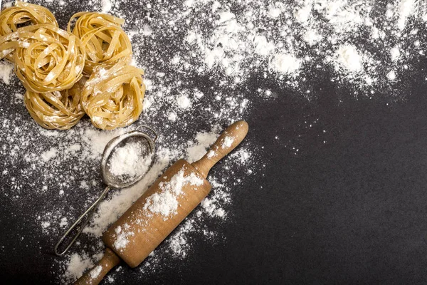 Pasta cruda tradicional italiana en el fondo de piedra negra, vistas superiores. — Foto de Stock