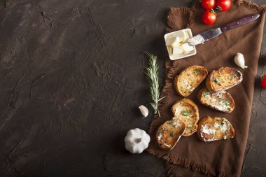 Tereyağlı, sarımsaklı, domatesli ve peçeteli ve koyu renkli otlu geleneksel tost ekmeği.