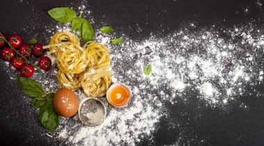 Siyah taş arka planda İtalyan geleneksel çiğ makarnası, üst manzara.