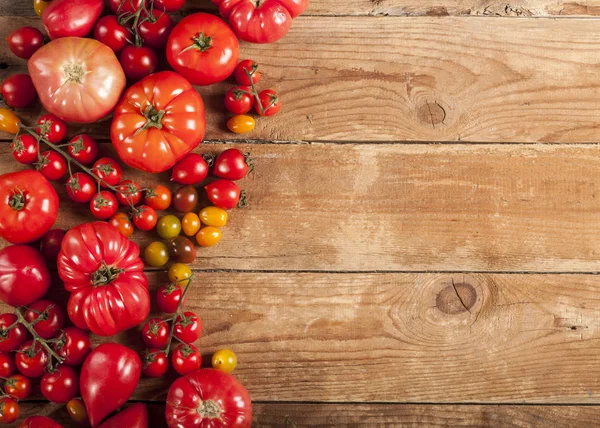 Tomaten op rustieke houten achtergrond bovenaanzicht kopieerruimte. — Stockfoto