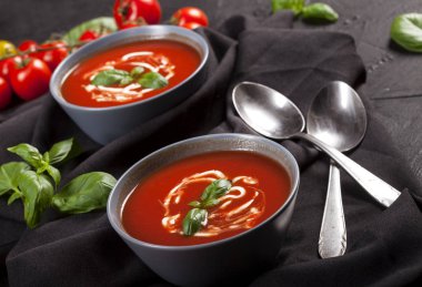 Geleneksel İspanyol usulü soğuk domates çorbası siyah taş arka planda bir kasede..