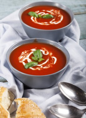 Geleneksel İspanyol soğuk domates çorbası çorbası. Mavi ahşap arka planda bir kasede..