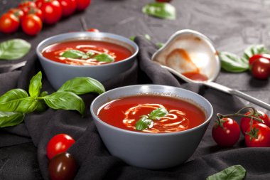 Geleneksel İspanyol usulü soğuk domates çorbası siyah taş arka planda bir kasede..