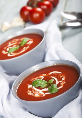 Geleneksel İspanyol soğuk domates çorbası çorbası. Mavi ahşap arka planda bir kasede..