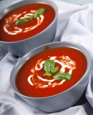 Geleneksel İspanyol soğuk domates çorbası çorbası. Mavi ahşap arka planda bir kasede..