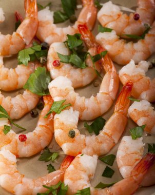 Limon, sarımsak ve bitkilerle dolu bir tabakta karides..