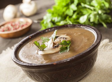 Maydanozlu lezzetli kremalı mantar çorbası ve koyu bir arka planda yakın plan..